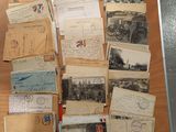 de nombreuses cartes postales anciennes posées sur une table, dont il y a beaucoup