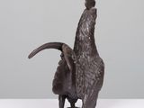 a bronze sculpture of a goat with horns on its back