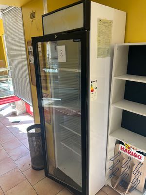 a glass door refrigerator in the middle of a room