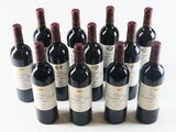 several bottles of wine are lined up in a row on a white surface
