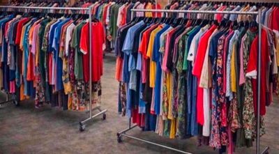 beaucoup de vêtements suspendus à une étagère dans un magasin