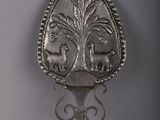 a silver spoon with a design on it on a table