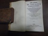 un livre ouvert posé sur une table, avec un étui en cuir