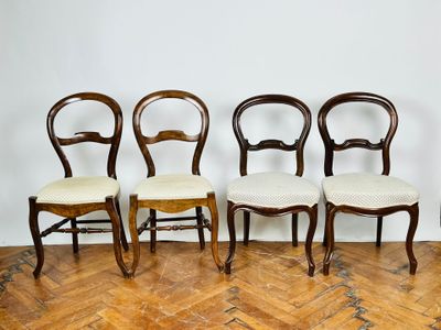 quatre chaises sont alignées en rangée sur un plancher en bois