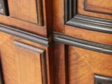 a close up of a wooden cabinet with black handles