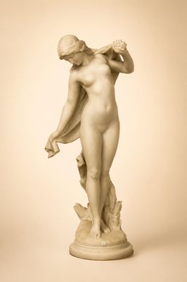 statue d'une femme nue tenant une fleur à la main