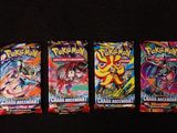three packs of pokemon cards are lined up on a black surface