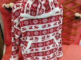 a red and white sweater sitting on a bed