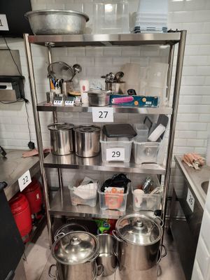 many pots and pans on the shelf in the kitchen