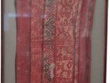 framed picture of a piece of cloth with a red and black design