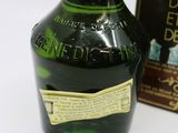 a green bottle with a label on it next to a box