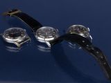 deux montres sont posées l'une à côté de l'autre sur une surface bleue