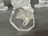 three clear glass figurines of a woman and a horse on a table
