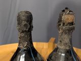 two wine bottles that are sitting on a wooden table