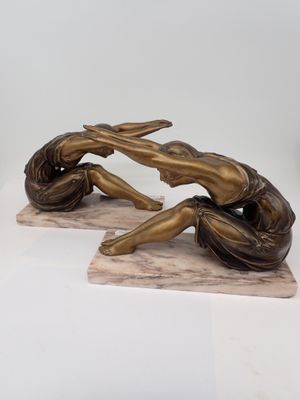 statue en bronze représentant deux femmes assises sur un socle en marbre