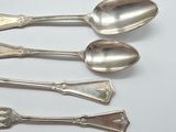 four silver spoons and two spoons on a white surface