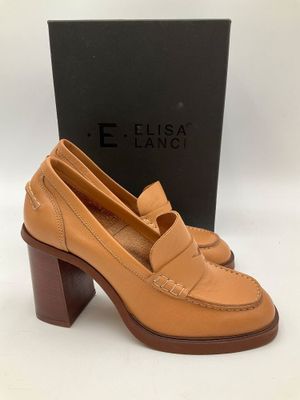 une paire de chaussures en cuir beige à talon en bois et une boîte
