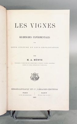 an open book sitting on top of a metal stand on a table