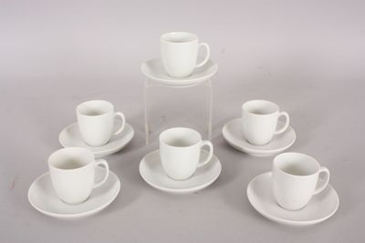 six cups and saucers sitting on a table