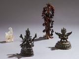 Plusieurs statues de formes et de tailles variées sont disposées sur une surface blanche