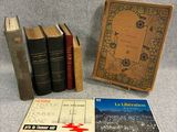 three books are sitting on a table next to a book case