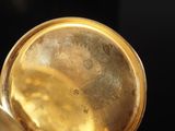 a close up of a gold plate with a black background