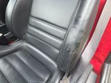 a picture of a black leather car seat with a red seat cover