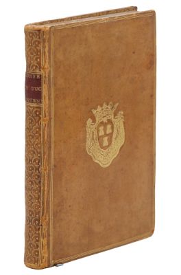 un vieux livre avec un emblème en or sur la couverture