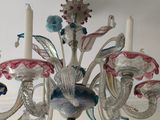 a chandelier that has a bunch of glass flowers on it