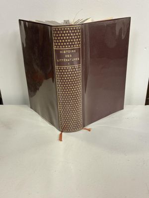 un vieux livre posé sur une table blanche à côté d'une chaise