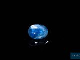 un gros plan d'une pierre bleue et blanche sur une surface noire
