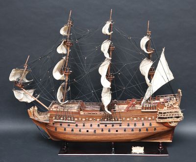 une maquette en bois d'un grand voilier posée sur un socle