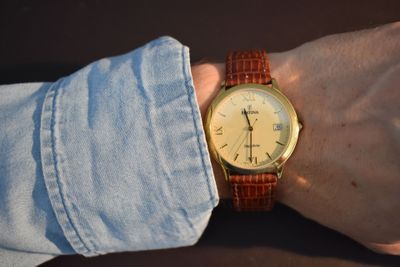 un homme portant une montre au poignet, la main posée sur son poignet
