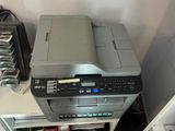 a printer sitting on top of a bookshelf in the corner of a room