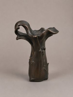 sculpture en bronze représentant un vase en forme de tronc d'arbre sur fond gris
