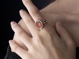 quelqu'un porte une bague sertie d'une pierre rouge