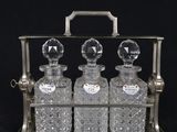 three glass bottles in a metal holder on a black background