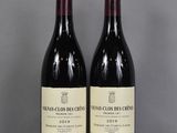 two bottles of wine sitting on top of a table next to each other