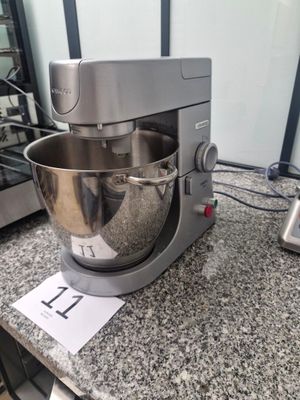 a silver mixer on a granite counter top next to a blender