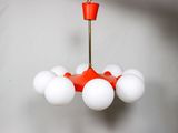 un lustre rouge et blanc auquel sont suspendues des boules blanches