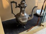 a silver tea pot on display in a glass case