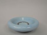 a blue bowl with a ring on it on a table