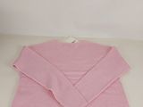 a pink sweater sitting on top of a white table next to a pair of scissors
