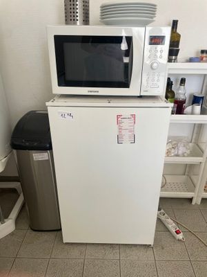 un petit réfrigérateur blanc surmonté d'un micro-ondes