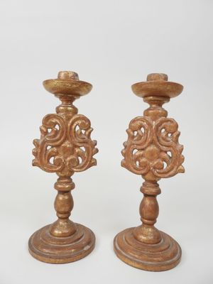 pair of wooden candlesticks with ornate designs on them