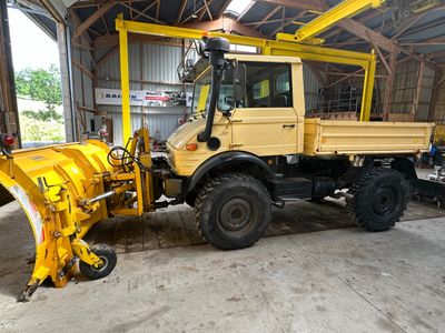 un gros camion jaune équipé d'une lame à neige à l'arrière