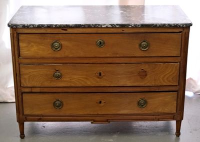 a wooden chest of drawers with a marble top