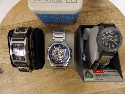 two watches and a watch box on a wooden table