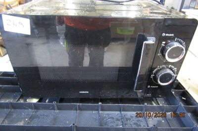 un micro-ondes noir posé sur une boîte bleue