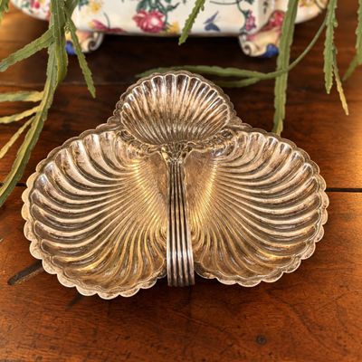 un plateau en argent orné d'une fleur, posé sur une table